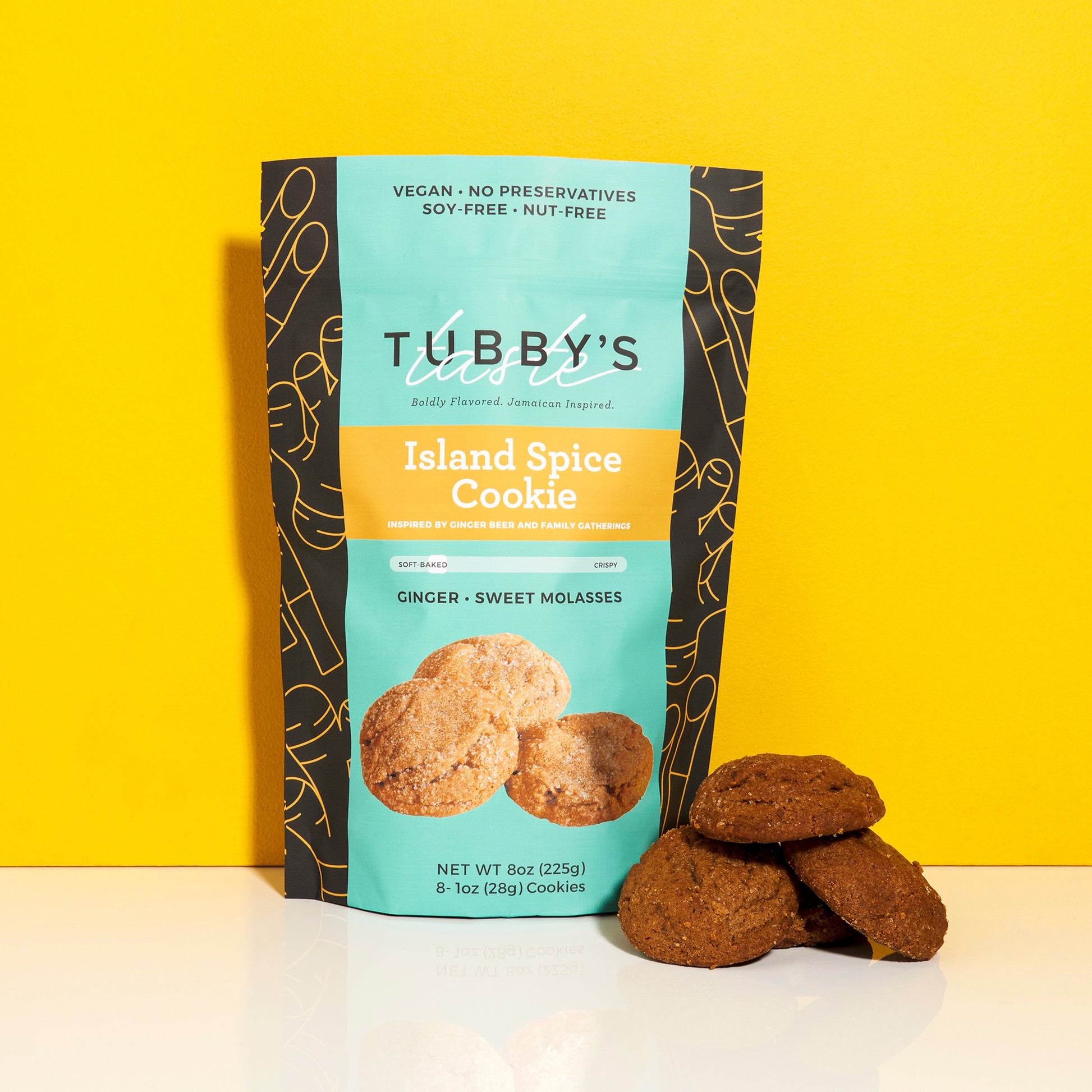 Four ginger molasses cookies with Tubby's Taste bag labeled Island Spice on a bright yellow and white backgorund.