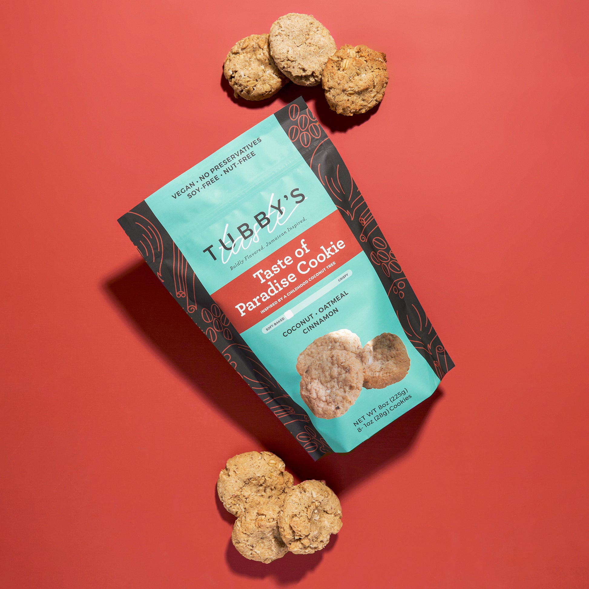 Six coconut oatmeal cinnamon cookies come out of a Tubby's Taste Taste of Paradise Cookie bag on a red background.
